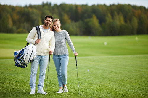 Couple on golf course wearing casual clothes