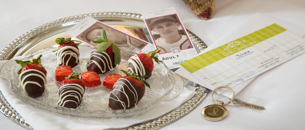 chocolate covered strawberries on a bed with tickets to the Baseball Hall of Fame