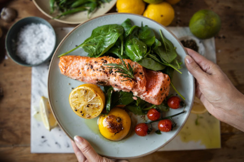 Beautiful plate with salmon spinach and grilled lemons