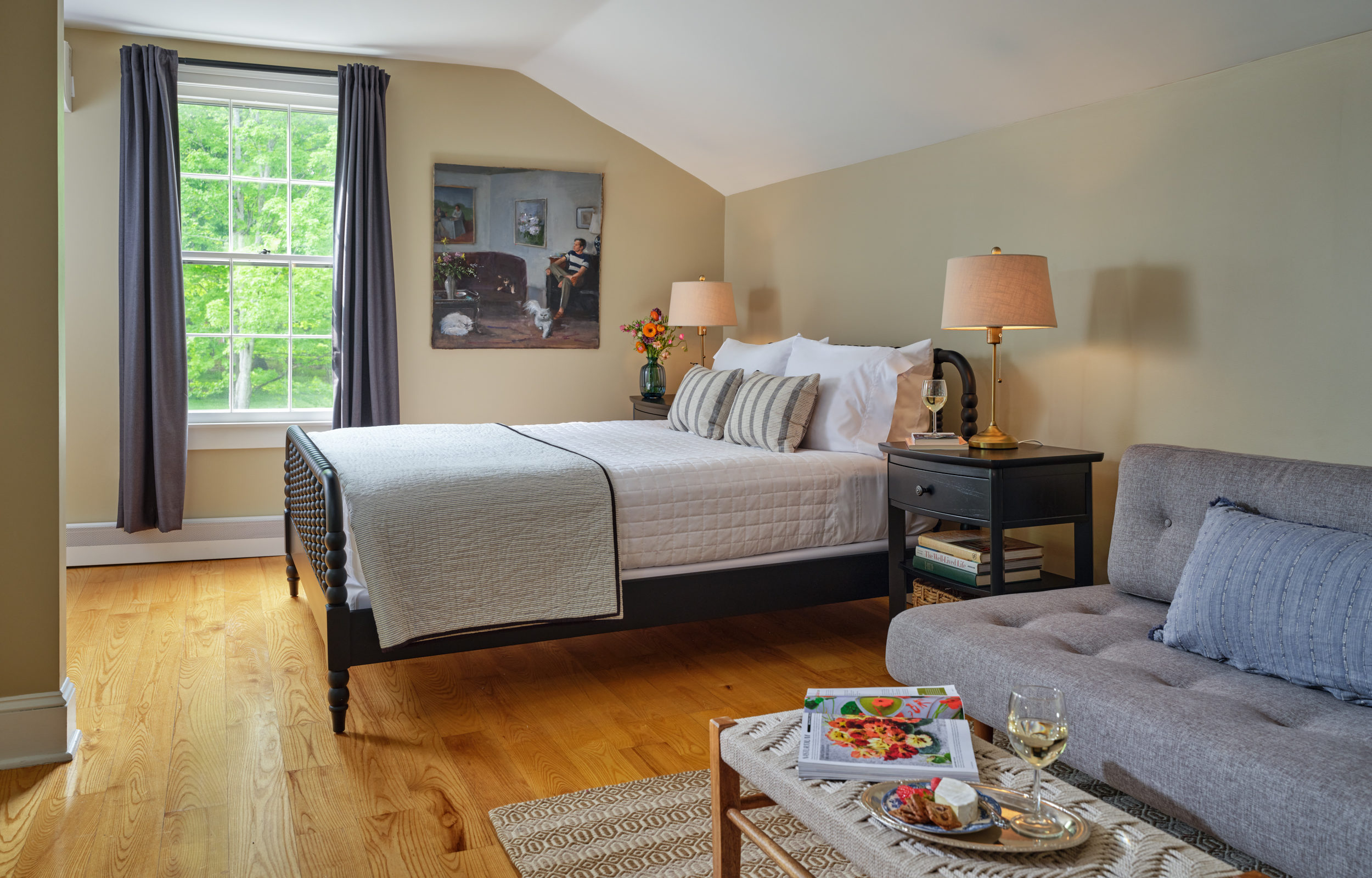 Comfortable queen bed and a private sitting area with a convertible sofa in the Metcalf Suite