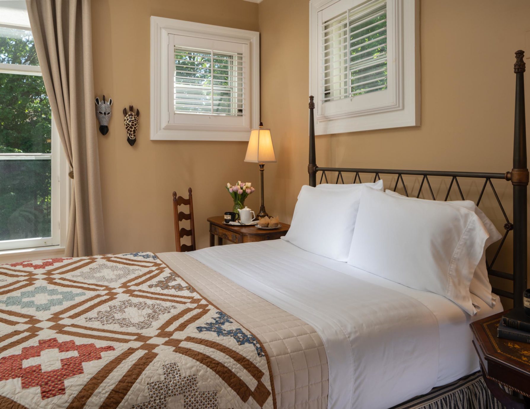 Plush bed with iron-frame headboard at an Upstate NY B&B