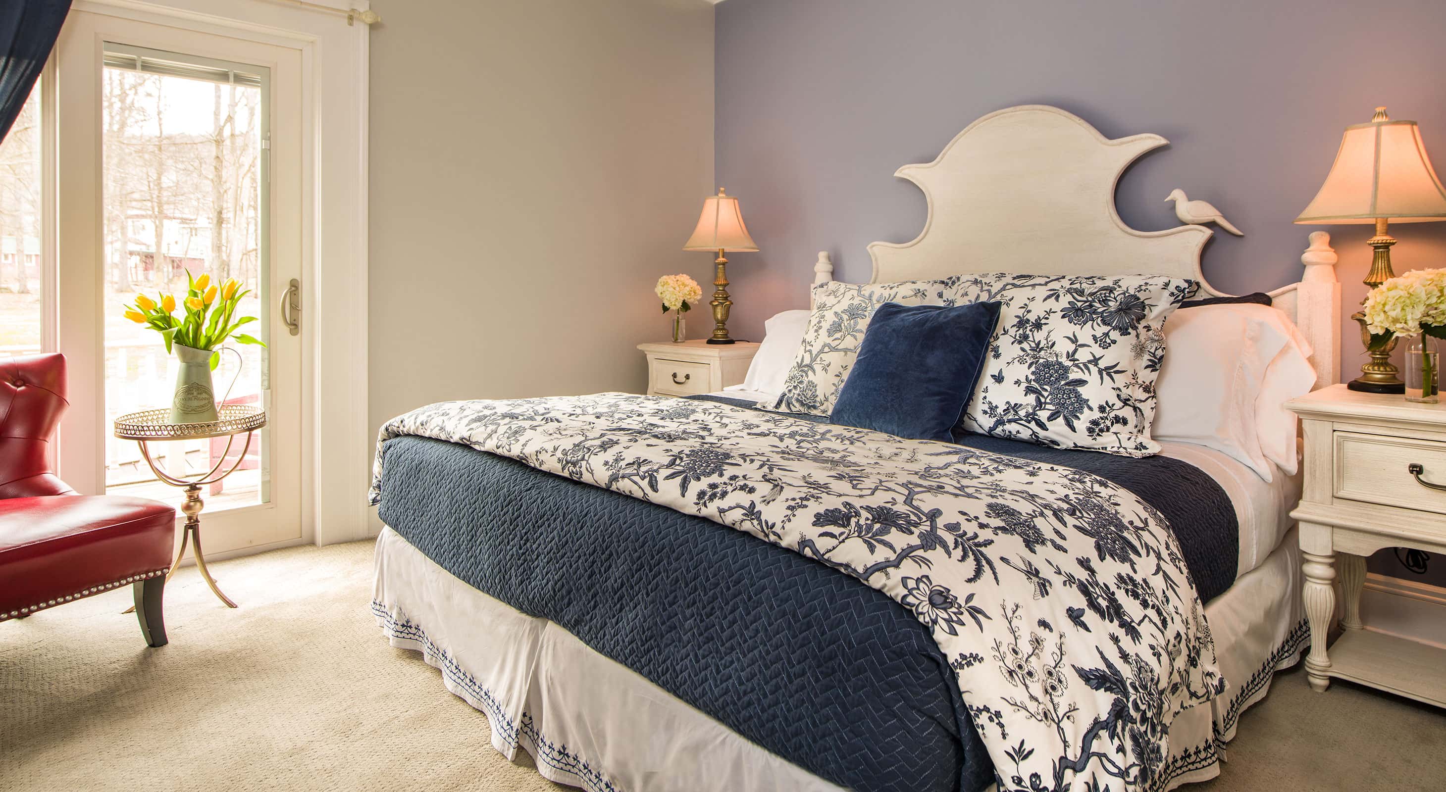 Petite Provence II's bed with soft pillows and intricate headboard