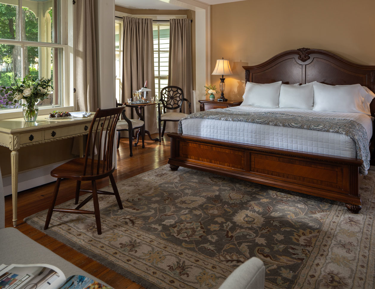 Wide bed by bright window sitting area in the Chance Room - Boutique Hotel in Upstate NY