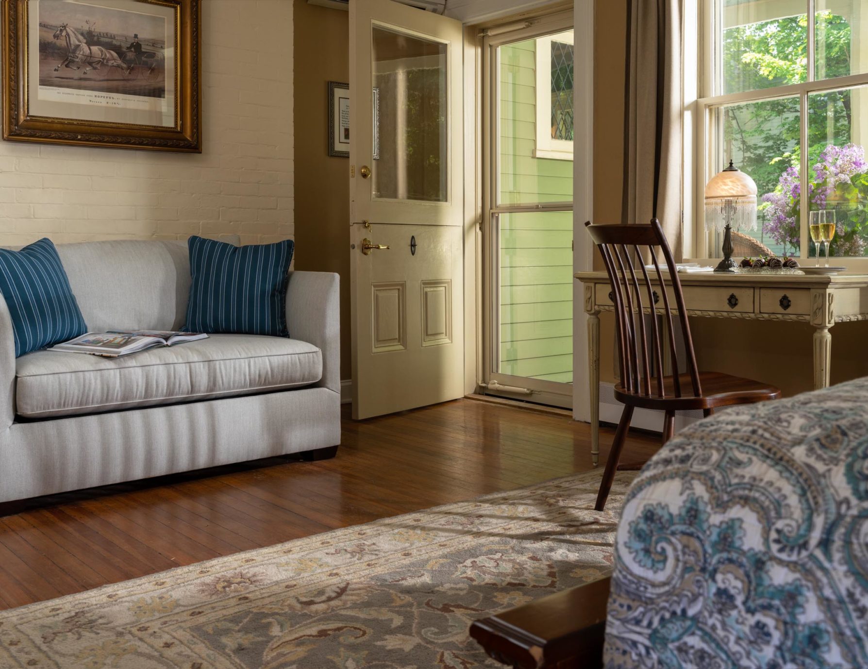 Writing desk and couch in front of bright window at a Cooperstown Inn