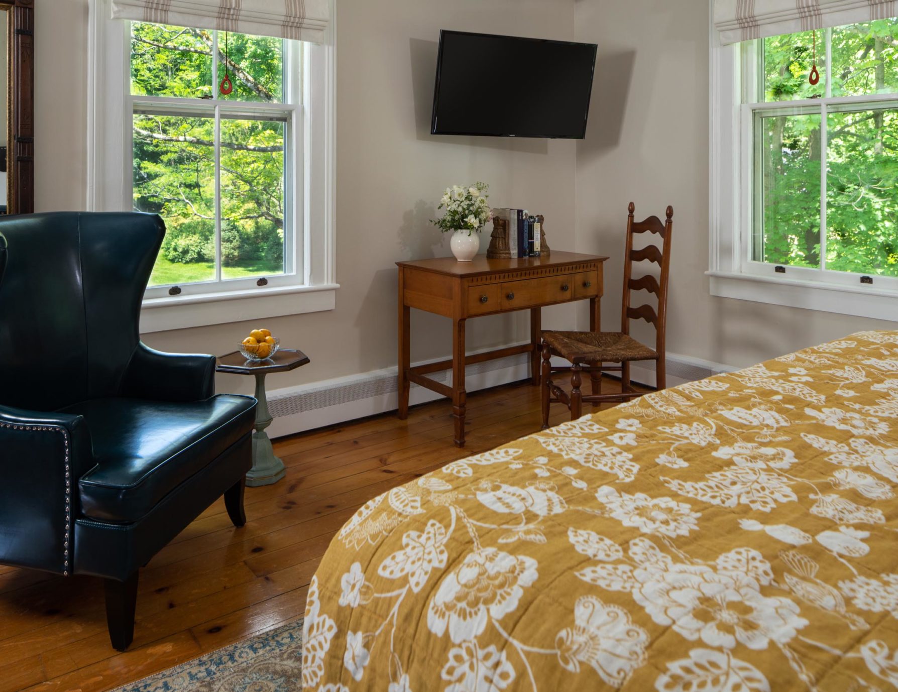 Lounge chair table with chair and bed at a Cooperstown Bed and Breakfast