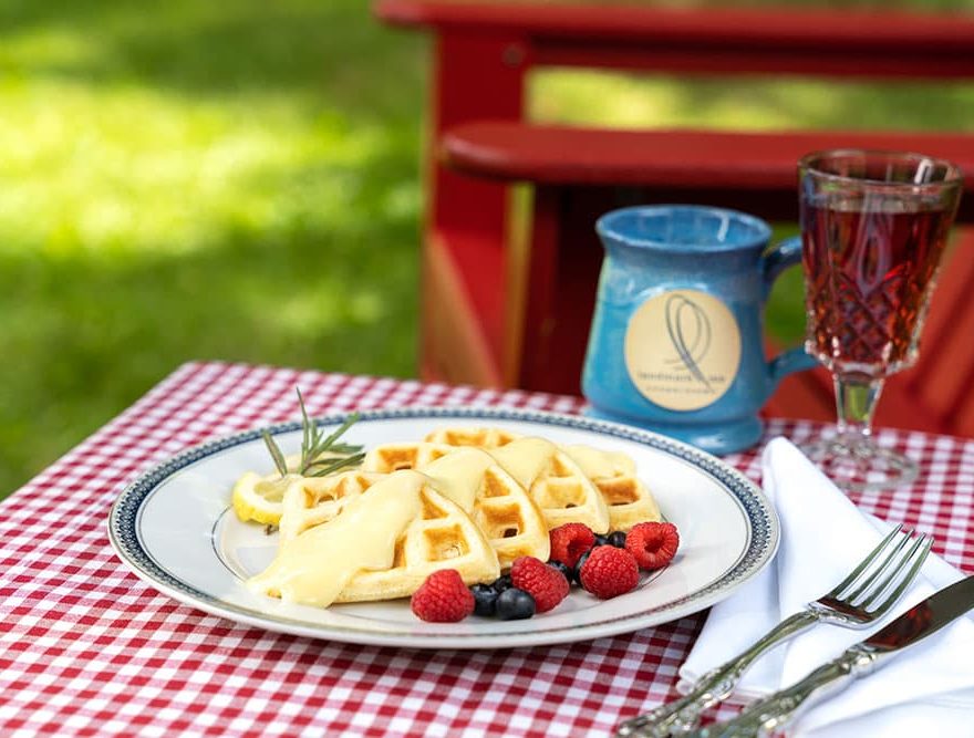 Breakfast waffles on table by Adirondack chairs