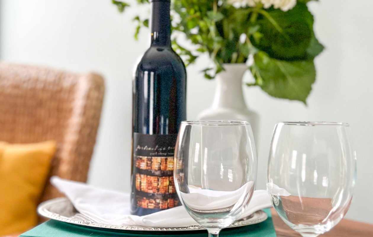 Bottle of wine with glasses outside on a picnic blanket