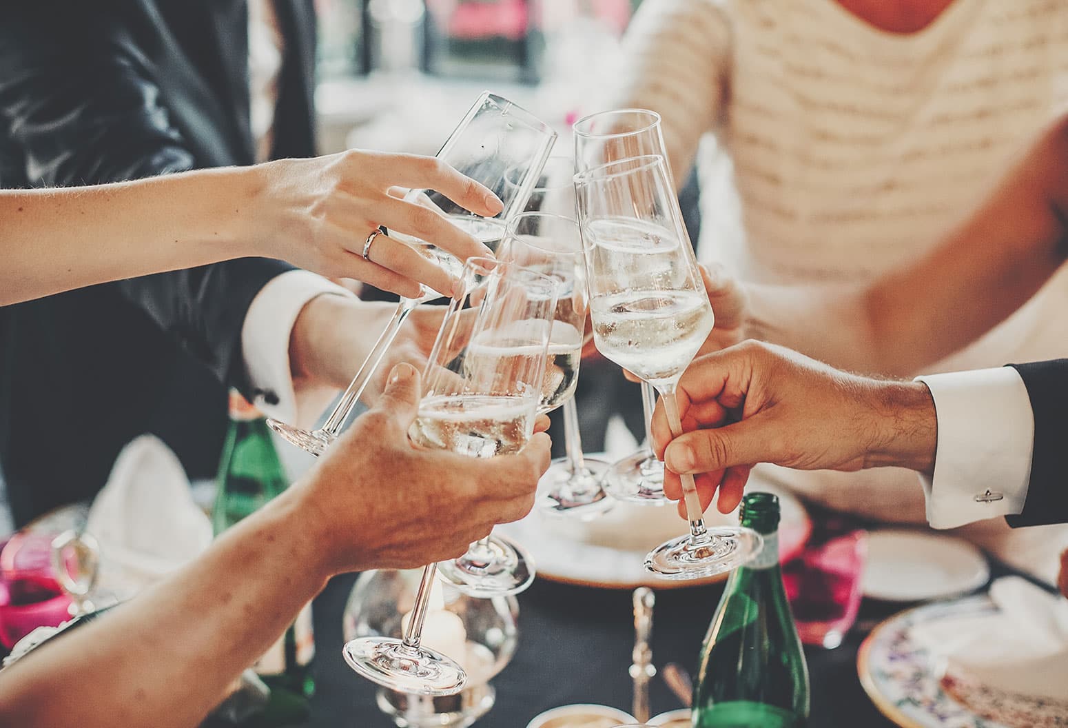 Friends and family clink glasses in a toast at wedding in Upstate NY