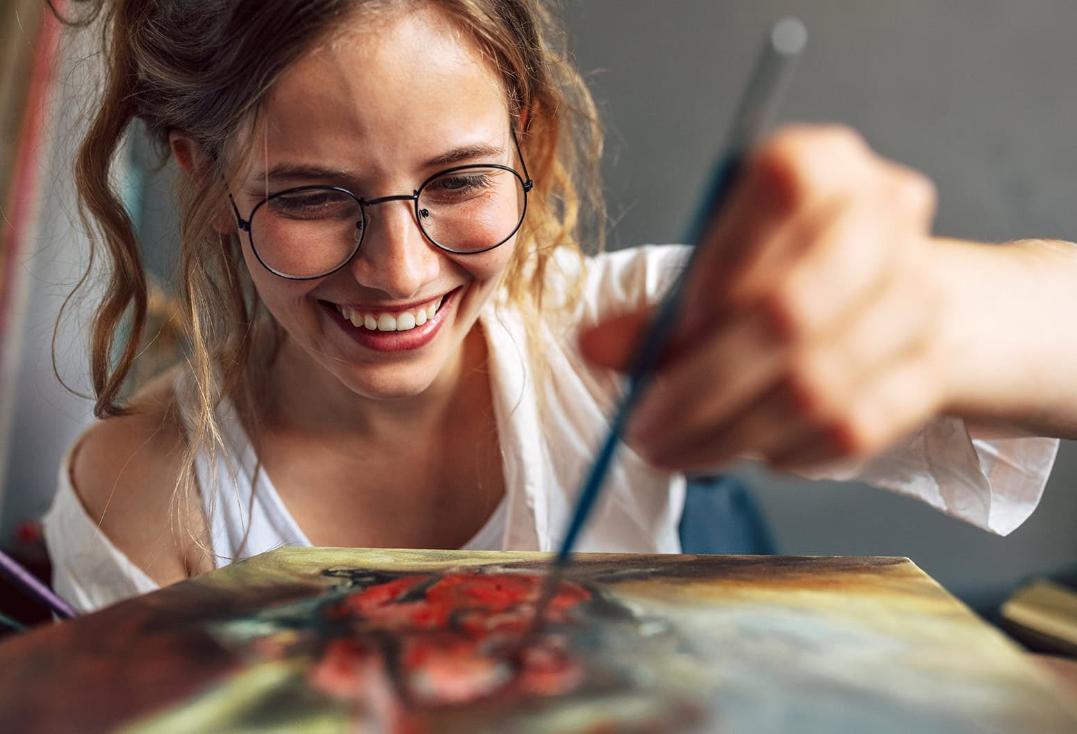 smiling woman painting with a paint brush