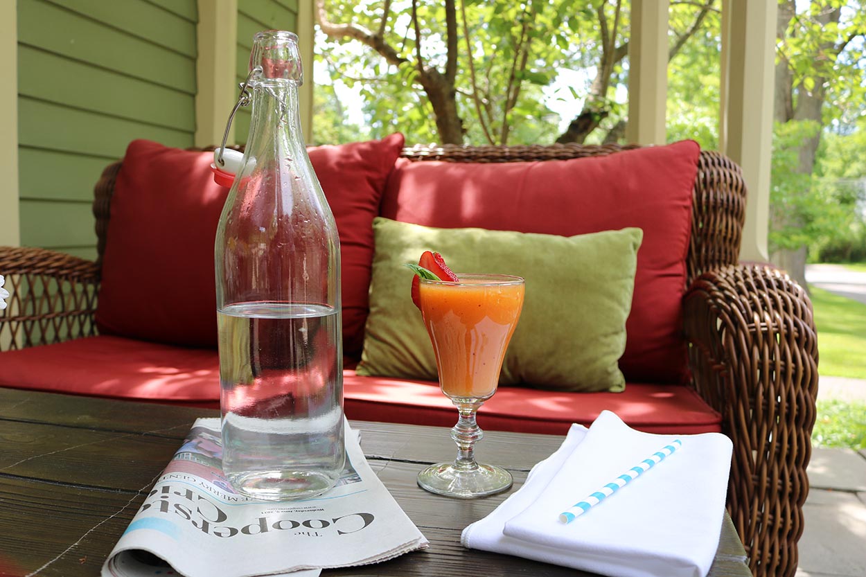 Smoothie and a bottle of water on a table outside
