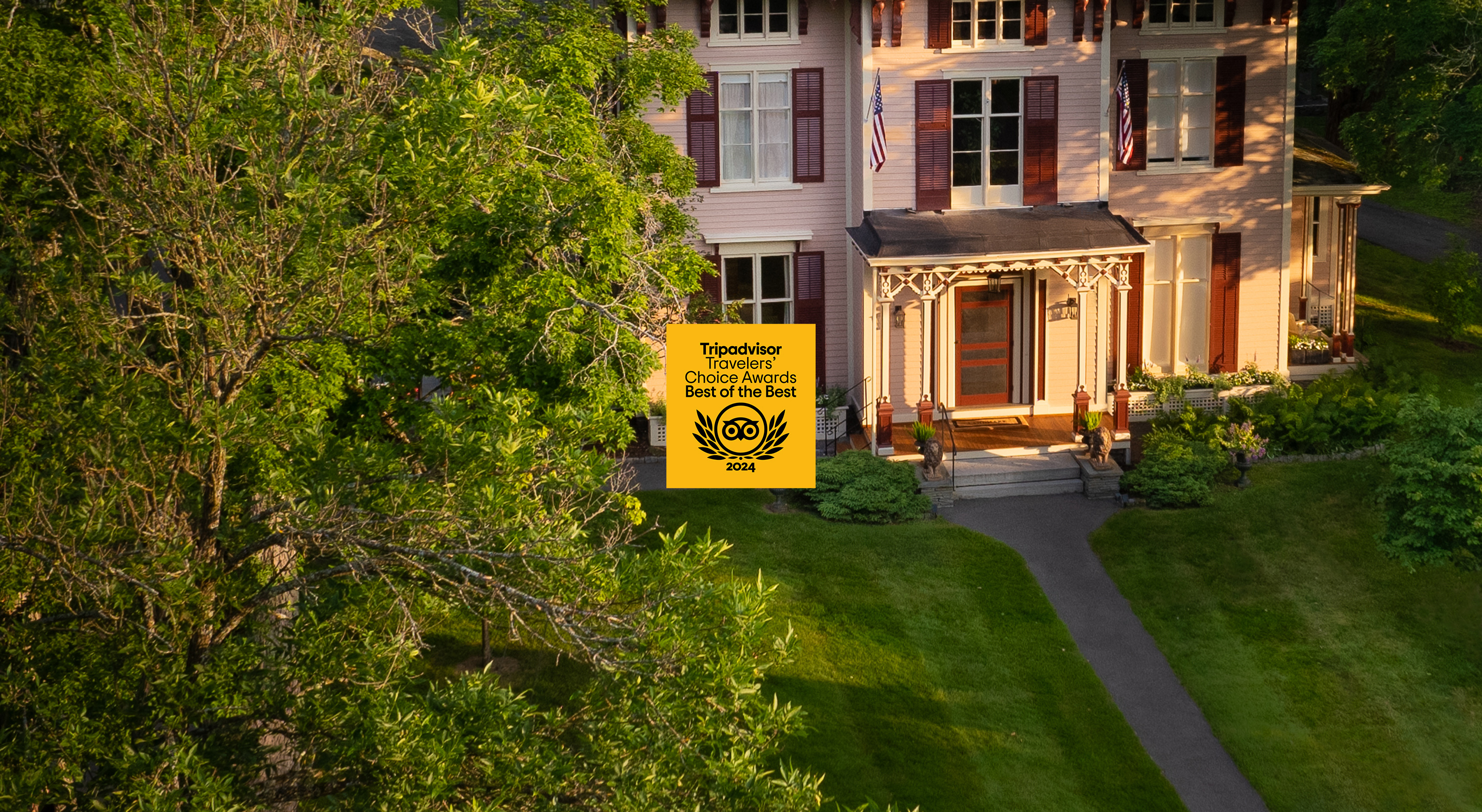 Exterior of inn at sunrise with 2024 Travelers Choice logo from TripAdvisor